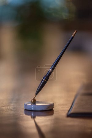 Photo for Fountain pen in a pen holder on an elegant wooden desk for ceremonies and business - Royalty Free Image