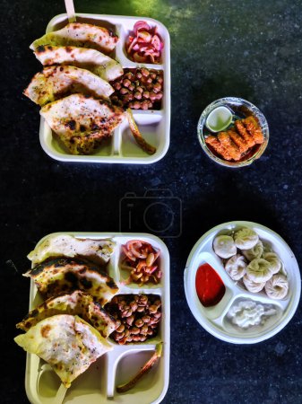 Téléchargez les photos : Photo d'un repas combo servant des momos chinois, Punjabi Chole Kulche et Paneer Pakoda. Industrie alimentaire et des boissons Inde - en image libre de droit