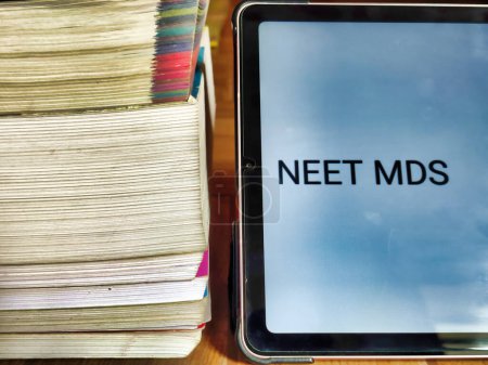 Picture of books and a placard with NEET MDS written on it kept on a table. Entrance Exam preparation