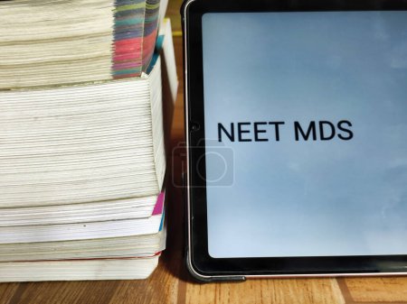 Picture of books and a placard with NEET MDS written on it kept on a table. Entrance Exam preparation