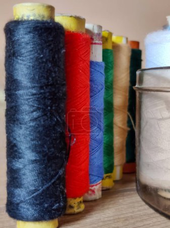 Photo for Picture of set of colorful spool of thread shot against blur background - Royalty Free Image