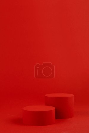 Luxury bright red scene with single cylinder podium mockup on table for presentation cosmetic products, gifts, goods in fashion trendy modern style, copy space, vertical. Template for advertising, design, card.