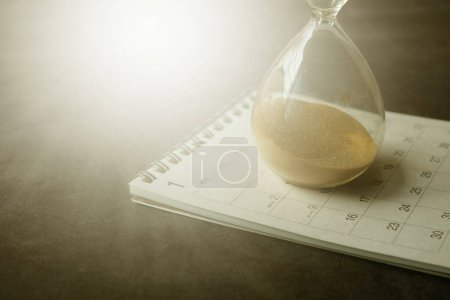 Photo for Hourglass on table, Sand flowing through the bulb of Sandglass. - Royalty Free Image