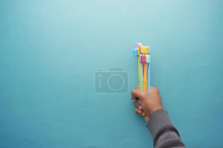 Foto de Vista superior de los hombres que sostienen cepillos de dientes de colores en el fondo de color , - Imagen libre de derechos