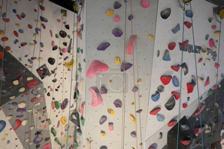 Téléchargez les photos : Mur d'escalade artificiel avec rochers de préhension colorés. Images 4k de haute qualité - en image libre de droit