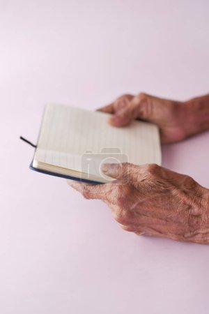 Photo for Senior omen hand turning a pager of a diary . - Royalty Free Image