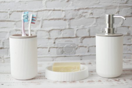 Téléchargez les photos : Brosses à dents colorées dans une tasse blanche contre un mur . - en image libre de droit