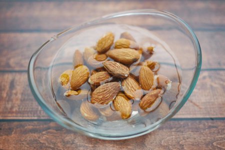 Close up of almond nuts in a bowl of water .