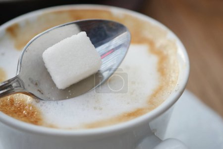 slow motion of pouring white sugar in a coffee cup , top view ,