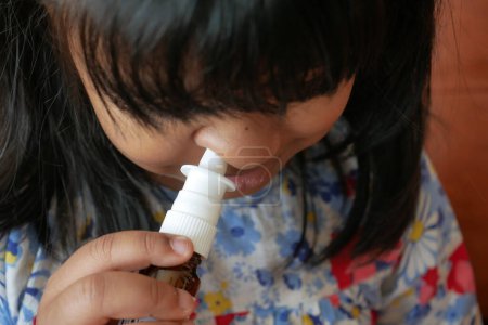 Nahaufnahme eines kranken Kindes mit Nasenspray.