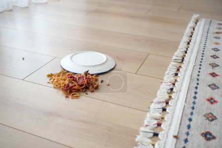 Espaguetis y salsa derramados en el suelo..