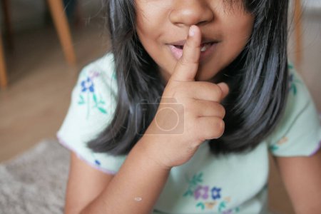  Kind hebt die Hand und deutet an, aufzuhören zu reden oder zu schweigen .
