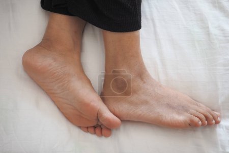  jeune femme couchée avec les pieds nus dans le lit