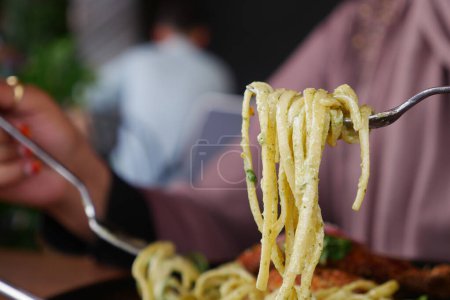  Fermeture d'une fourchette avec des spaghettis dans un cadre de restaurant italien de charme.