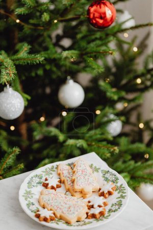Foto de Galletas decoradas del árbol de Navidad con manchas rojas y blancas borrosas en el fondo del árbol de Navidad - Imagen libre de derechos