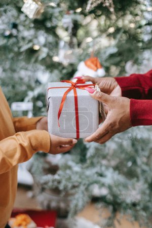 Foto de Persona dando una caja de regalo envuelta en blanco regalo sorprender a otra persona en Navidad - Imagen libre de derechos