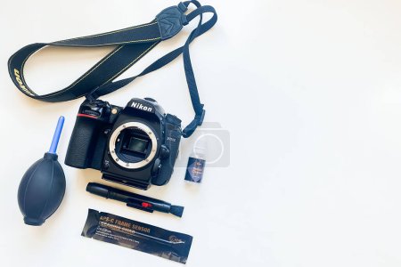 Photo for USA - 27th may, 2022: Top view close up camera sensor and lens cleaning tools with dslr camera on white background. Selective focus. Brush, blower, camera, swab, liquid tube - Royalty Free Image