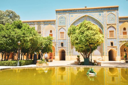 Téléchargez les photos : Shiraz, Iran - 6 juin 2022 : École khan Cour persane avec jardin verdoyant à Madrese e-Khan. L'ancienne école religieuse est une attraction touristique populaire du Moyen-Orient. - en image libre de droit