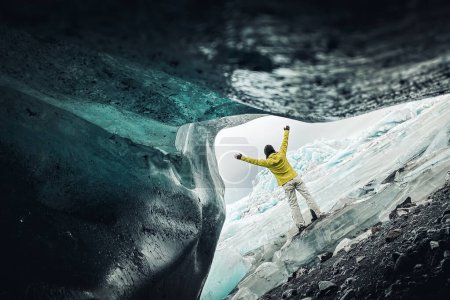 Téléchargez les photos : Une touriste se tient près du magnifique glacier Fjallsjkull en Islande par temps couvert. Grottes de glace en Islande. Vue depuis une petite grotte vide. - en image libre de droit