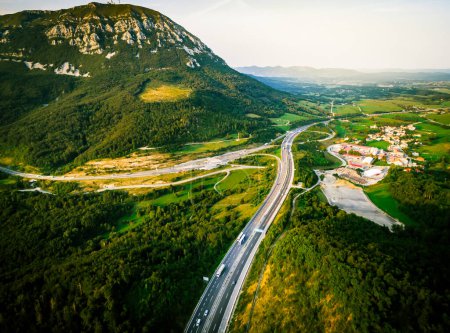 Photo for Aerial dramatic view Slovenian motorway road with lorry and cars with green meadow summer fields forest around in central Europe - Royalty Free Image