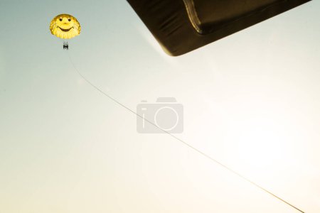 Photo for Three person family do para sailing in yellow parachute mid-air. Para-sailing and safety in water sports - Royalty Free Image