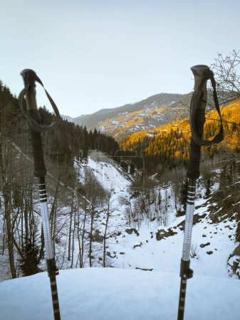Téléchargez les photos : Paysage panorama bâtons de randonnée sur le sentier de randonnée avec panorama des montagnes de caucase enneigées dans la soirée de printemps chaud et lumineux pendant le coucher du soleil. La neige fond Le printemps arrive - en image libre de droit