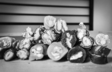 Schwarz-weiße Makro-Nahaufnahme von verschiedenen Arten von aufgeschnittenen Peaces von Churchchchhela mit Bankenhintergrund. Georgisches Fruchtsnacks-Konzept.