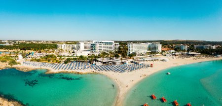 Ayia Napa, Zypern - 15. April 2023: Luftflug über Luxushotelgebäude mit Pool am Strand mit Inselpanorama. Weißer Sand berühmtester Strand Zyperns - Nissi-Strand