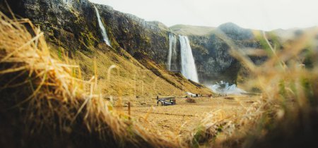 Foto de Seljalandsfoss, Islandia - 5 de marzo de 2023: grupos turísticos visitan la cascada Seljalandsfoss en Islandia en primavera. Pico temporada de vacaciones primavera, multitudes de verano y vacaciones de viaje - Imagen libre de derechos