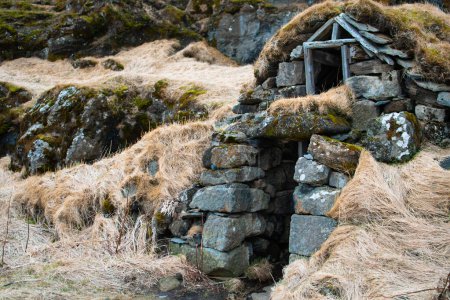 Rasenhaus am Fuße des Drangurinn Rock in Südisland. Das Eyjafjll-Gebirge im Süden Islands in der Nähe der Ringstraße, Route 1. Turfhouses, die mit Elfen, Folklore, Sagen und Legenden verbunden sind