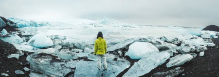 Cerca de la laguna glaciar Fjallsjokull con persona se encuentra en iceberg. La maravillosa laguna glaciar de Fjallsrln en Islandia se derrite