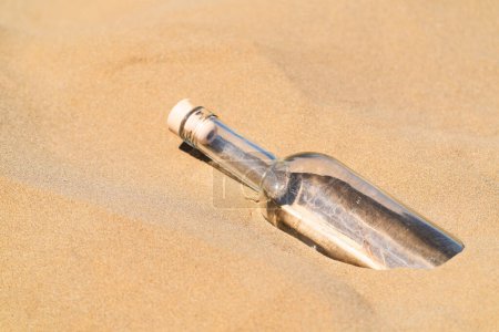 Photo for Bottle with a message in the sand. Ask for help SOS - Royalty Free Image
