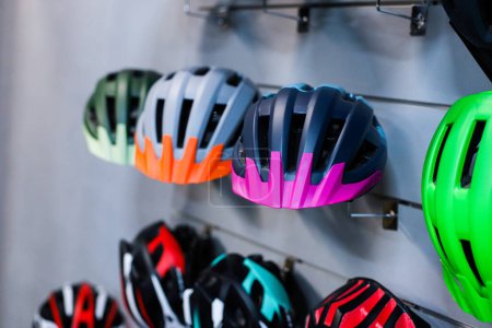 Photo for Focus on helmet. Bicycle helmets on the stand - Royalty Free Image