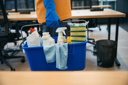 Photo for Cleaning service employee uses a special set of gadgets for cleaning and disinfection - a bucket, sponges, spray, napkins, detergents,gloves - Royalty Free Image