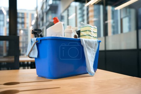 Foto de En la mesa hay un conjunto profesional de dispositivos para la limpieza y desinfección: un cubo, esponjas, aerosol, servilletas, detergentes - Imagen libre de derechos