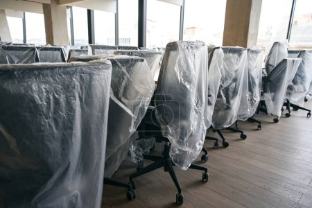 Téléchargez les photos : Espace de coworking dans le centre de bureau après désinfection et nettoyage général, espace de bureau propre avec mobilier couvert, design high-tech - en image libre de droit