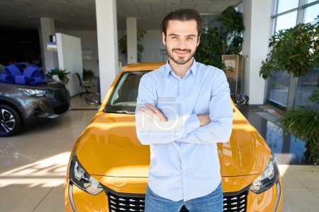 Photo for Smiling young man posing for camera in front of brand new luxury car - Royalty Free Image