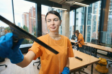 Photo for Cleaning company workers use different gadgets while cleaning and disinfecting all surfaces in the coworking space - Royalty Free Image