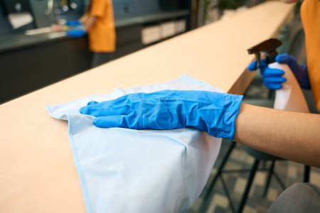 Téléchargez les photos : Nettoyage des employés de l'entreprise en uniforme nettoyer et désinfecter les surfaces, ils utilisent des gadgets spéciaux - en image libre de droit