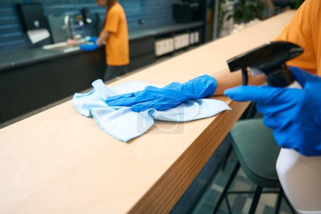 Téléchargez les photos : Nettoyage des travailleurs de l'entreprise en uniforme nettoyer et désinfecter les surfaces, ils utilisent des gadgets spéciaux - en image libre de droit
