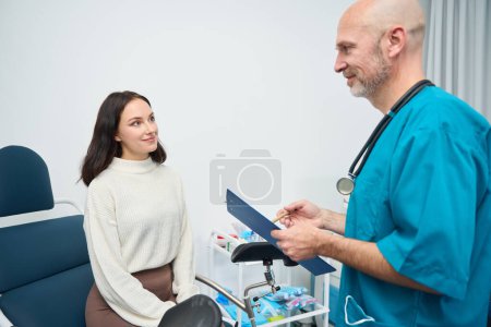 Photo for Joyful female listens attentively to a medical specialist while the two of them are in the office - Royalty Free Image
