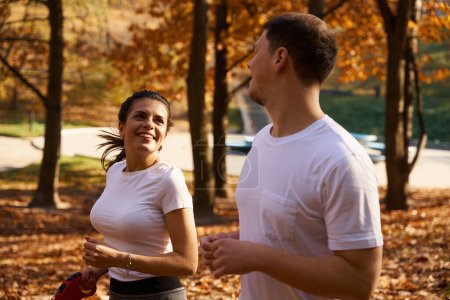 Téléchargez les photos : Couple étudiant court à travers le parc et communique cutely, dans les mains d'une femme une laisse de ruban à mesurer - en image libre de droit