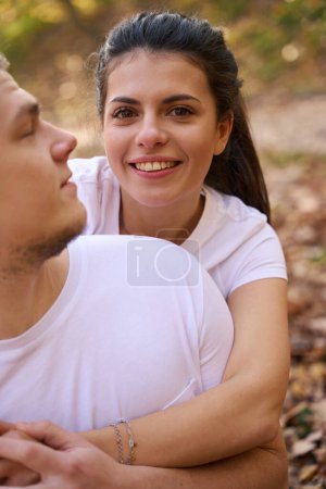 Téléchargez les photos : Charmante jeune femme aux yeux bruns embrassant son ami, ils se détendent dans la nature - en image libre de droit