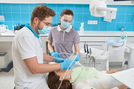 Foto de Dentista con experiencia escaneando paciente cavidad oral con escáner intraoral asistida por enfermera - Imagen libre de derechos