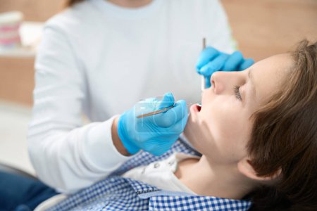 Photo for Child is given a filling in the dental office, the doctor uses special tools - Royalty Free Image