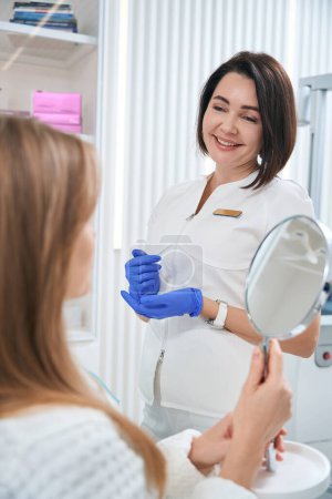 Foto de Woman cosmetologist communicates kindly with a patient, a consultation takes place in a cosmetology clinic - Imagen libre de derechos