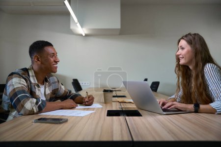 Foto de Happy two coworkers working together in the meeting room in the office - Imagen libre de derechos