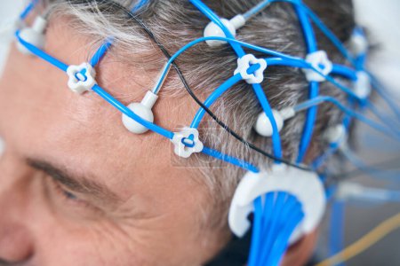 Téléchargez les photos : Middle-aged man on the diagnosis of EEG - electroencephalography, a cap of sensors on his head - en image libre de droit