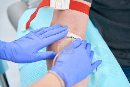 Photo for Patient gives a blood sample from a vein, the nurse carefully performs the procedure - Royalty Free Image