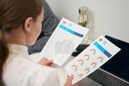 Photo for Cropped head back view portrait of woman doctor is looking through the examining of body indicators in medicine center - Royalty Free Image
